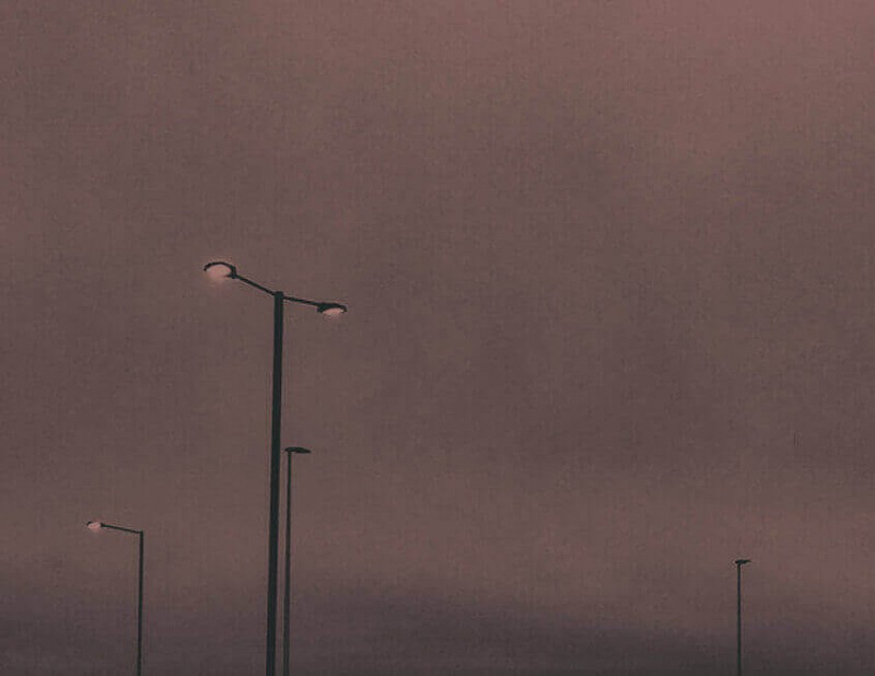 Streetlights against a red cloudy sky