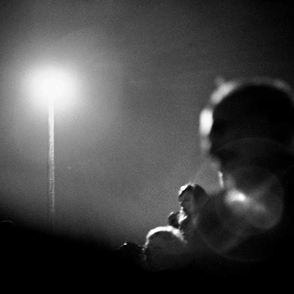 A person silhouetted by the light from a streetlight